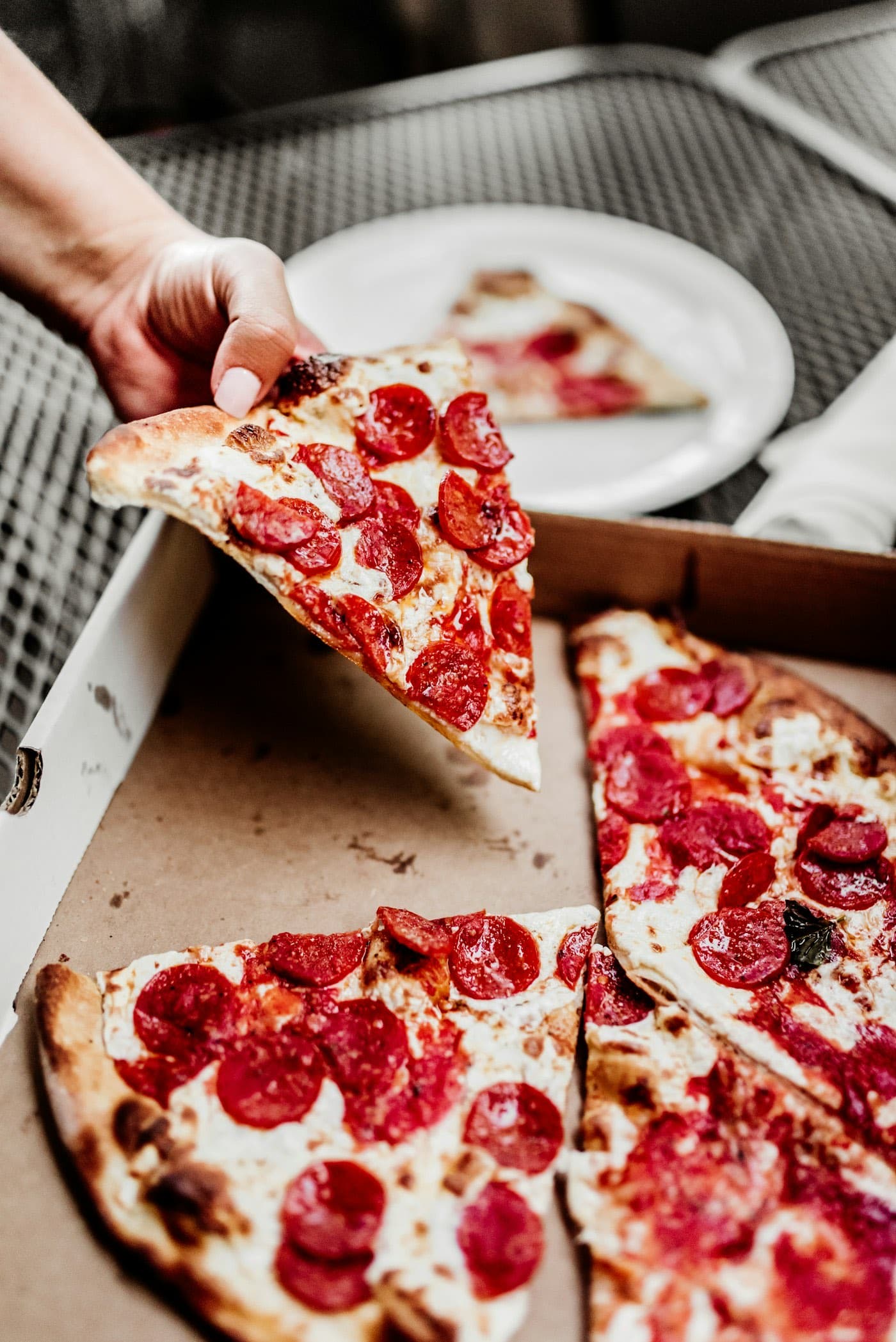A pepperoni pizza boxed for pickup